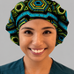 Nurse wearing Colorful Spirit African print bouffant scrub cap black background teal green gold geometric pattern surgical hat handmade OR World