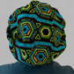 Nurse wearing Colorful Spirit African print bouffant scrub cap black background teal green gold geometric pattern surgical hat handmade OR World back view 