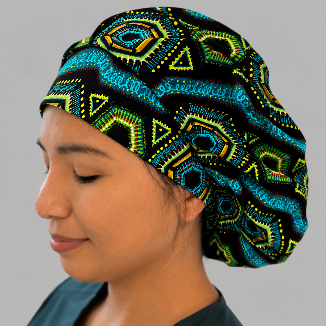 Nurse wearing Colorful Spirit African print bouffant scrub cap black background teal green gold geometric pattern surgical hat handmade OR World-side view