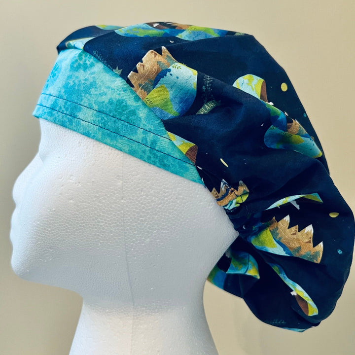 Side view of Save the Planet bouffant scrub cap with earth print on navy — handmade-in-USA surgical hat, meaningful gift for nurses &amp; surgeons.