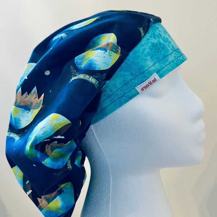 Save the Planet bouffant scrub cap, earth &amp; trees on navy blue, on a model — handmade-in-USA unisex surgical hat from OR World.