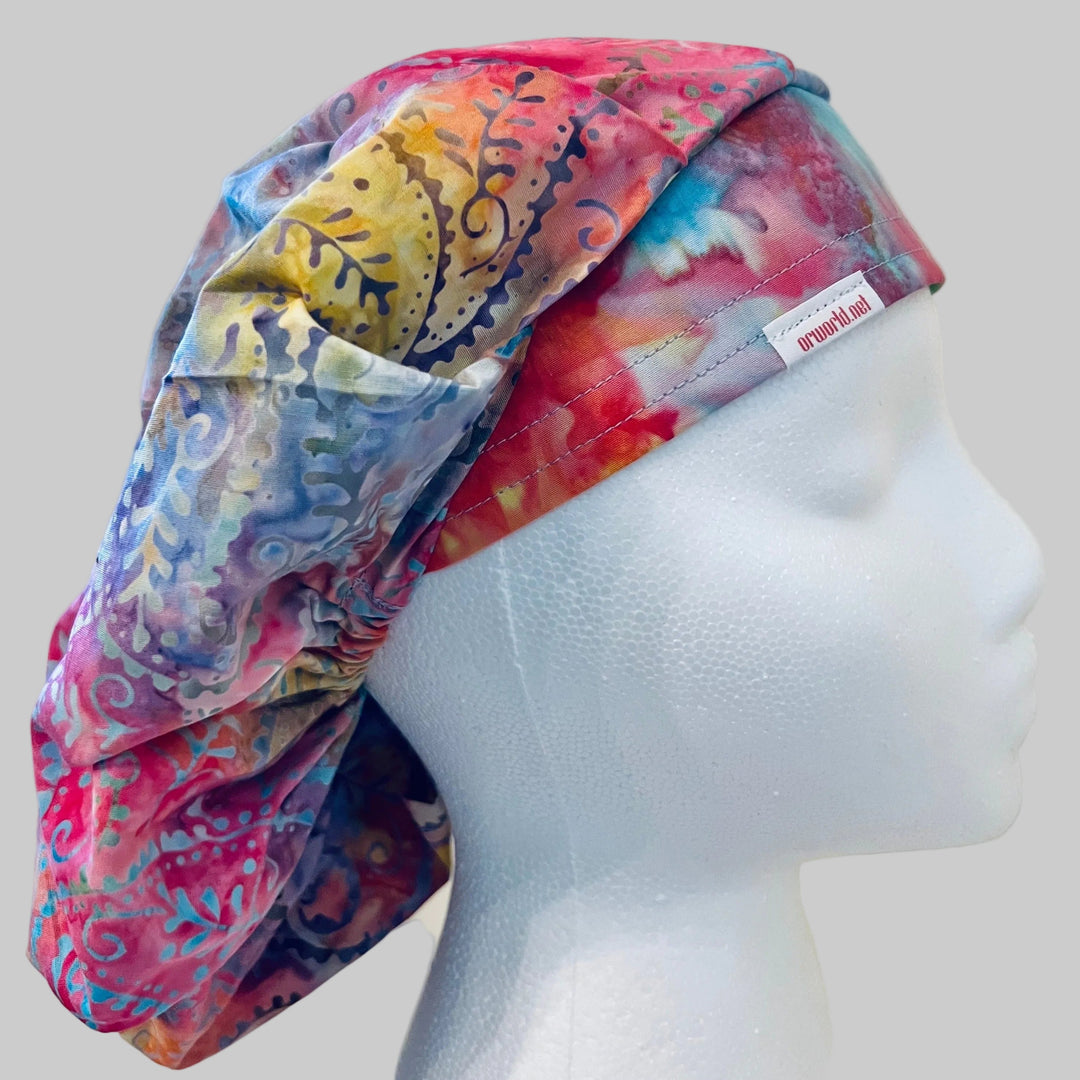 Pastel candyland batik bouffant scrub cap in pink, blue & lavender, on a model — handmade-in-USA surgical hat for women from OR World.