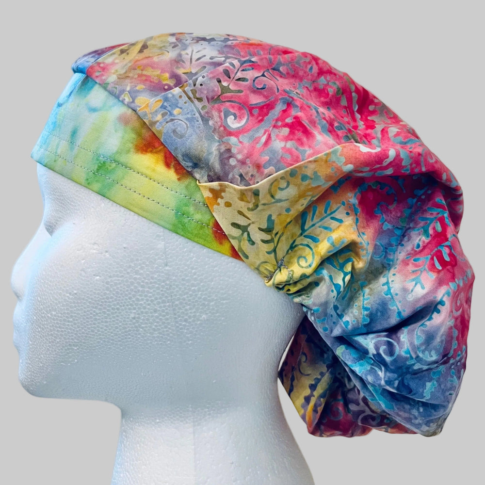 Side view of pastel pink, blue & lavender batik bouffant scrub cap — handmade USA surgical hat for OR nurses with room for long hair.