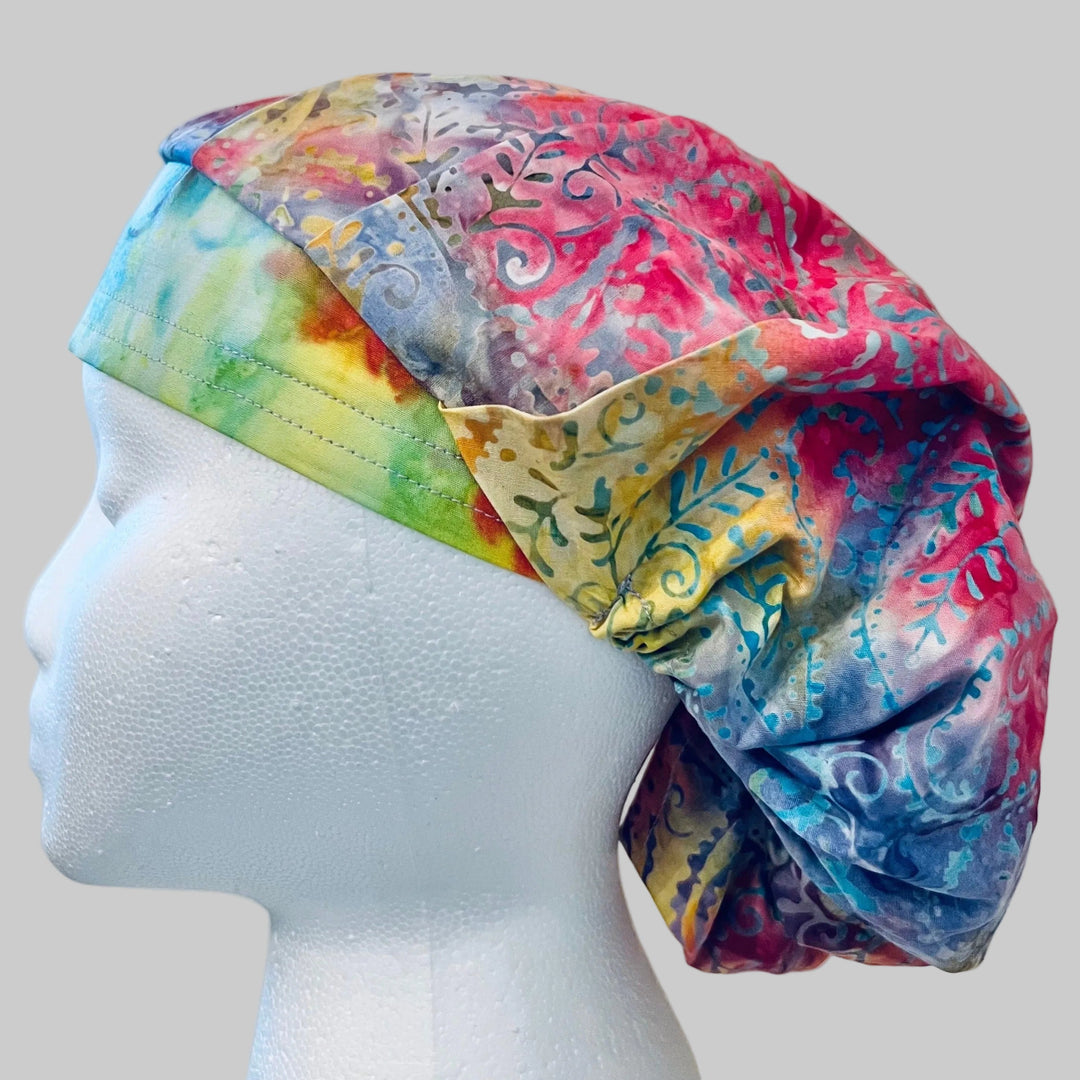Side view of pastel pink, blue &amp; lavender batik bouffant scrub cap — handmade USA surgical hat for OR nurses with room for long hair.