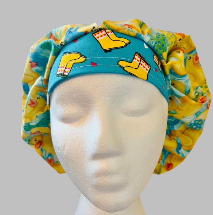 Front view of rubber duckies &amp; rain boots bouffant scrub cap — handmade USA aqua surgical hat for OR &amp; pediatric nurses with room for long hair.