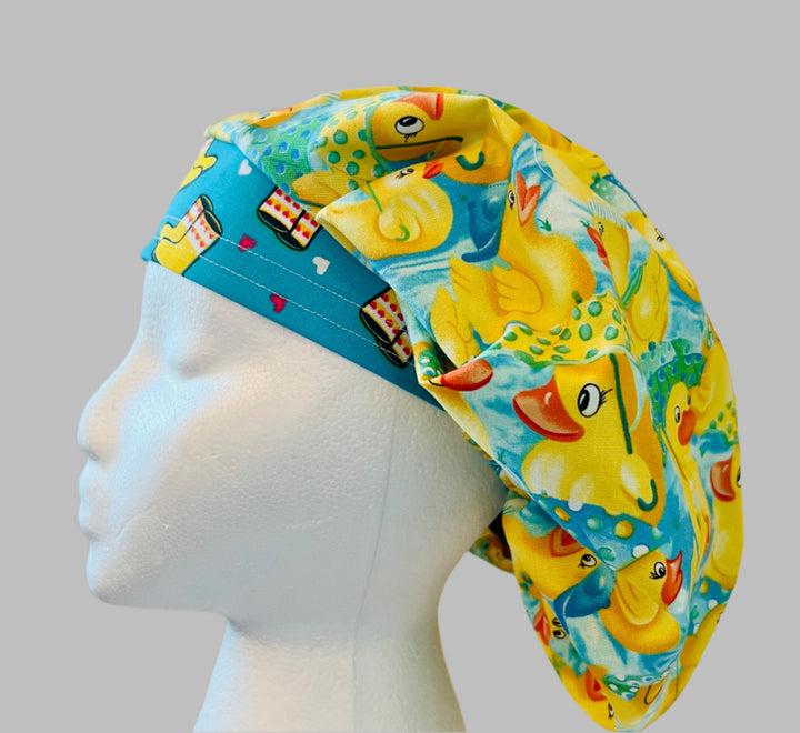 Side view of yellow rubber duckies bouffant scrub cap on aqua — handmade-in-USA surgical hat, fun gift for nurses &amp; pediatrics.