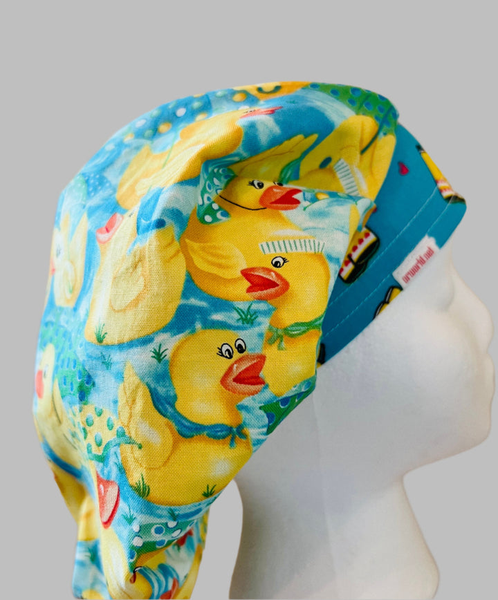 Rubber duckies bouffant scrub cap with rain boots band on aqua, on a model — handmade-in-USA surgical hat for women from OR World.