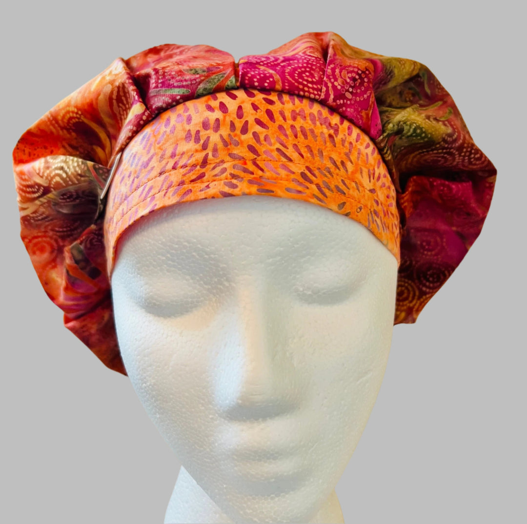 Side view of fuchsia &amp; orange batik bouffant scrub cap — handmade USA summer surgical hat with room for long hair.