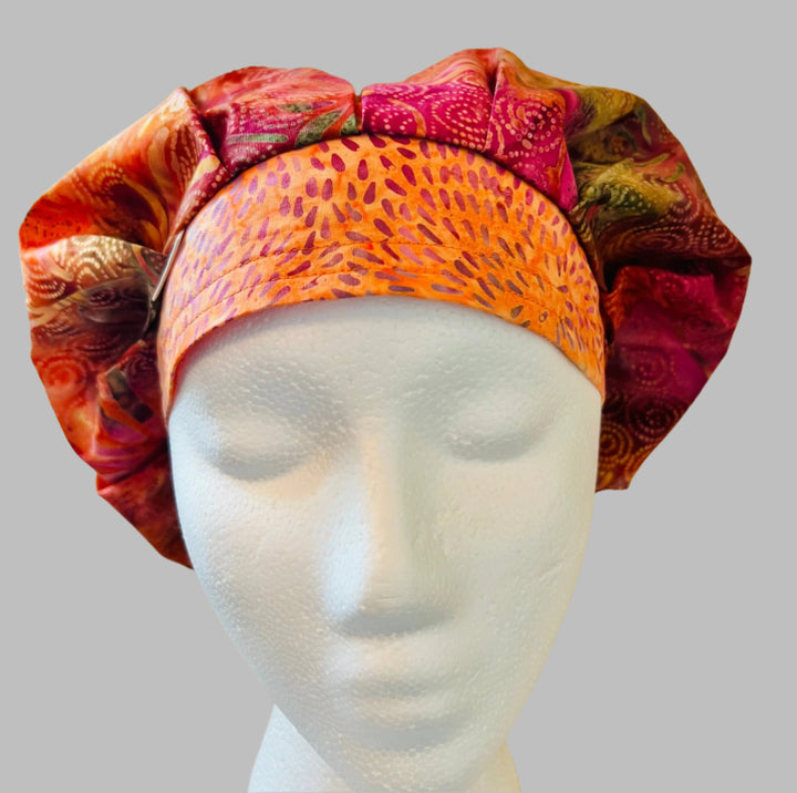 Side view of fuchsia &amp; orange batik bouffant scrub cap — handmade USA summer surgical hat with room for long hair.