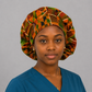 Nurse wearing African Kente Ghana bouffant scrub cap traditional orange green geometric pattern surgical hat teal scrubs OR World handmade