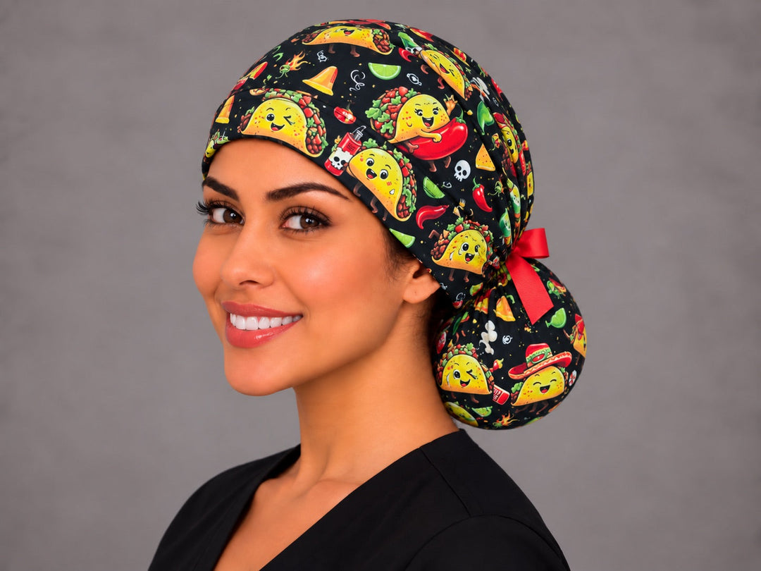 Taco ponytail scrub cap left angle view showing winking tacos, hot sauce and lime print along the side band with a red ribbon bow
