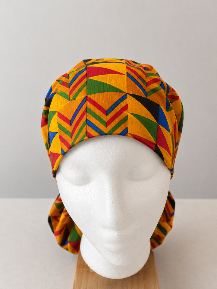 African Kente print XL ponytail scrub cap front view gold red green geometric pattern handmade surgical hat for nurses