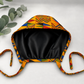 Colorful Geometric African Kente mens tieback scrub cap flat lay showing black satin lining interior bold Ghana triangle pattern surgical hat handmade USA OR World