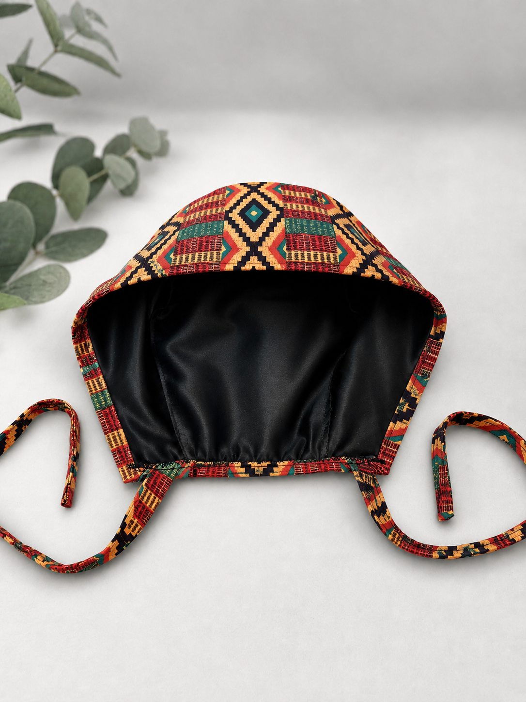 Empowered Energy African Kente mens tieback scrub cap flat lay showing black satin lining interior traditional Ghana diamond pattern surgical hat handmade USA