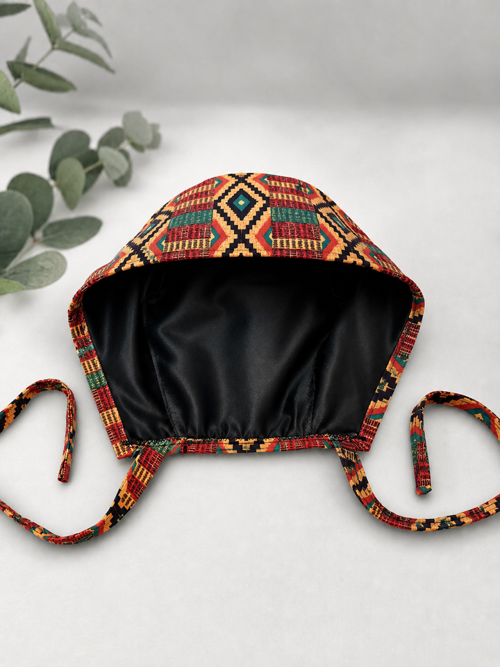 Empowered Energy African Kente mens tieback scrub cap flat lay showing black satin lining interior traditional Ghana diamond pattern surgical hat handmade USA