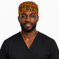 Male healthcare professional wearing Empowered Energy African Kente mens tieback scrub cap traditional Ghana diamond pattern gold red green surgical hat black scrubs OR World