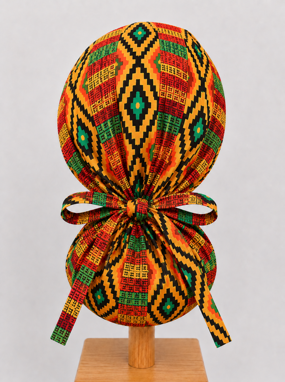 Empowered Energy African Kente ponytail scrub cap back view showing tie closure traditional Ghana diamond Kente print orange green teal surgical hat handmade USA