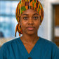 Nurse wearing African Kente Ghana original ponytail scrub cap traditional orange green brown black geometric pattern surgical hat hospital setting teal scrubs OR World