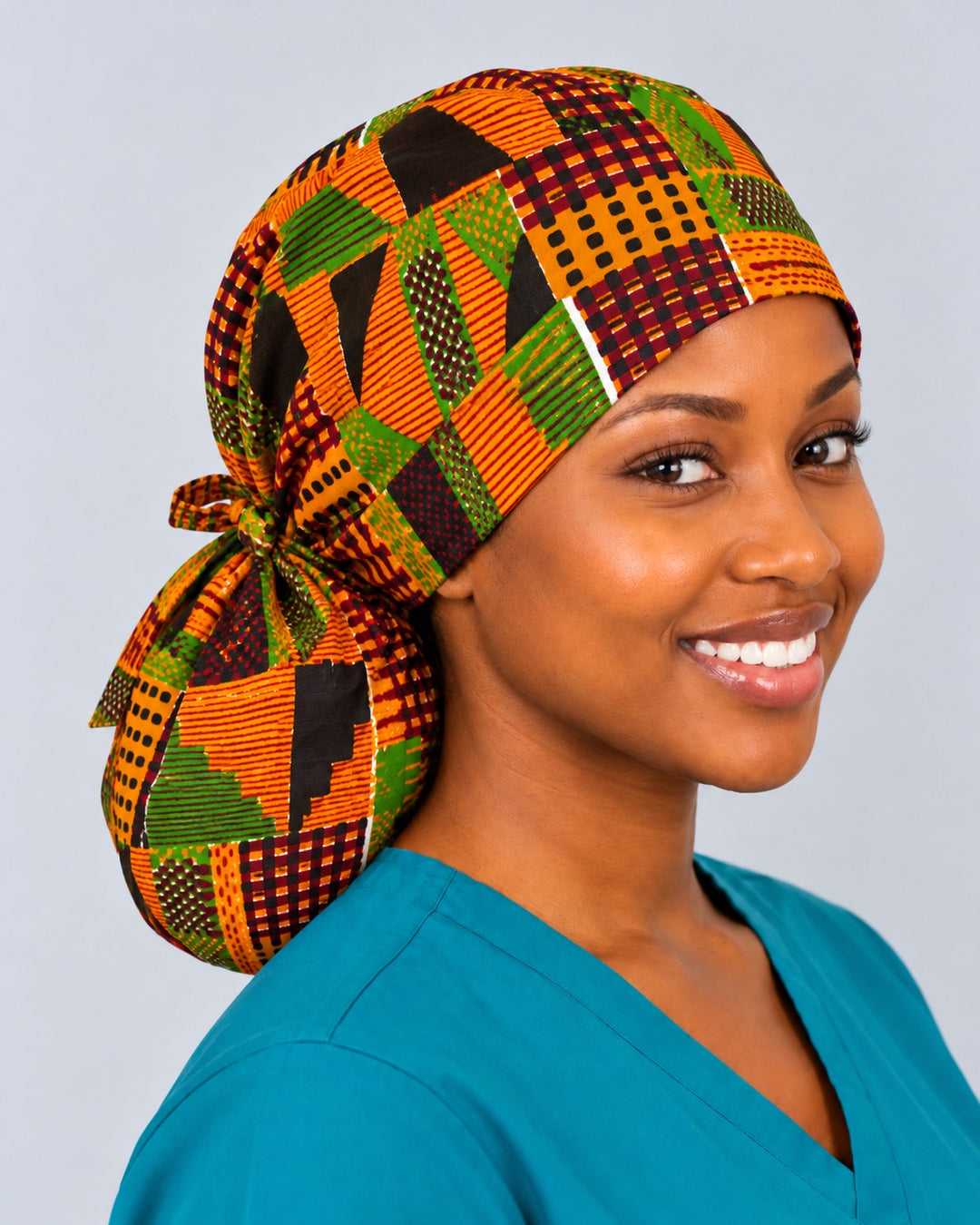 Right three-quarter view of an African Kente ponytail cap with room for long braids, showing black stepped blocks and dotted squares across the roomy crown