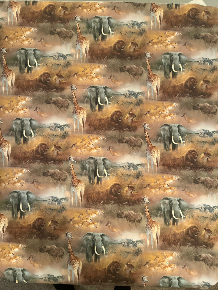 Close-up of African safari wildlife fabric with elephants, lions, giraffes &amp; zebras on golden grasslands — handmade-in-USA OR World scrub cap.
