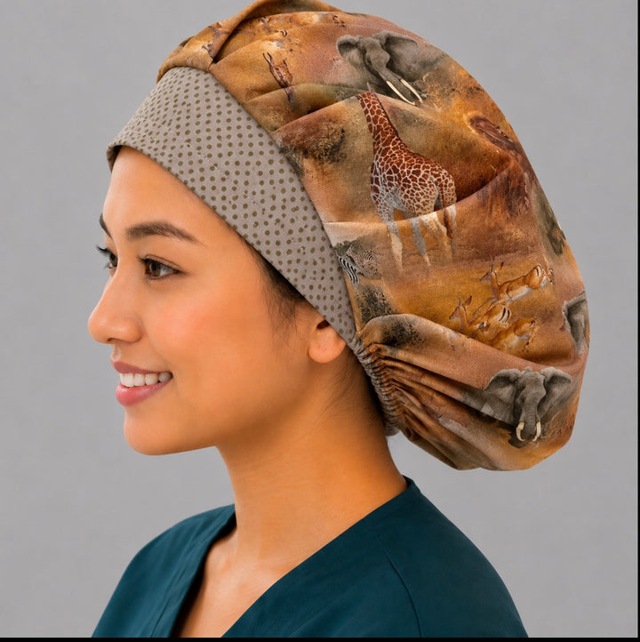 African safari bouffant surgical cap left side profile showing giraffe, elephant and antelope savanna scene with gold dot band, OR World