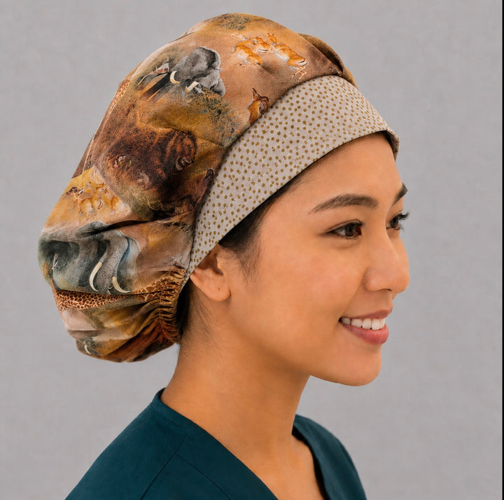 African safari wildlife bouffant scrub cap right side profile showing elephant, bison and giraffe print with gold dot band, women&