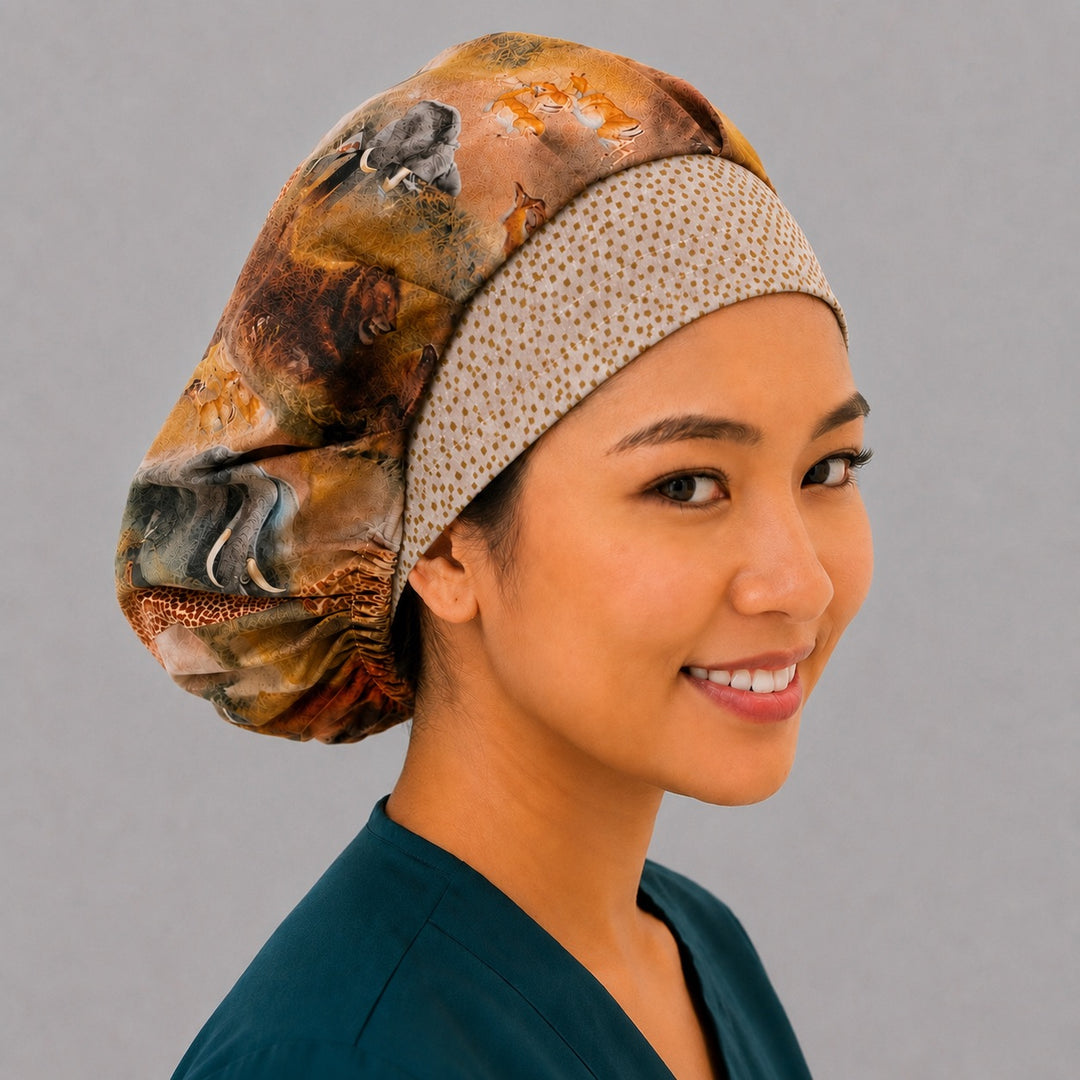 African safari wildlife bouffant scrub cap right three-quarter angle on smiling model showing elephant and giraffe savanna print with gold dot band, OR World