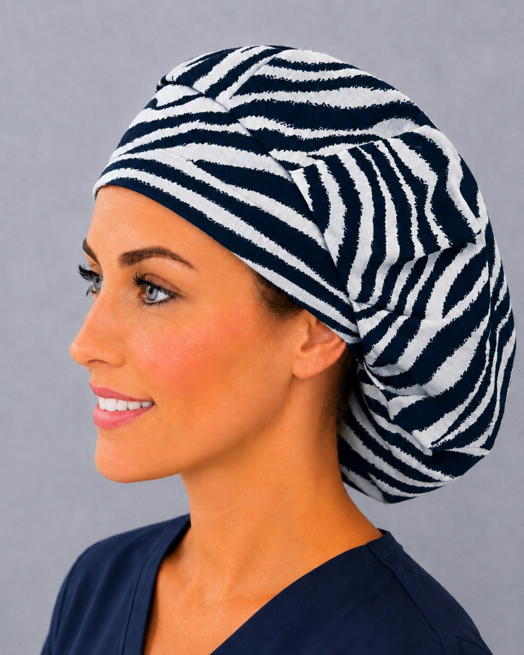 Animal print zebra bouffant scrub cap, left side profile — roomy elastic-back fit that secures long thick or braided hair