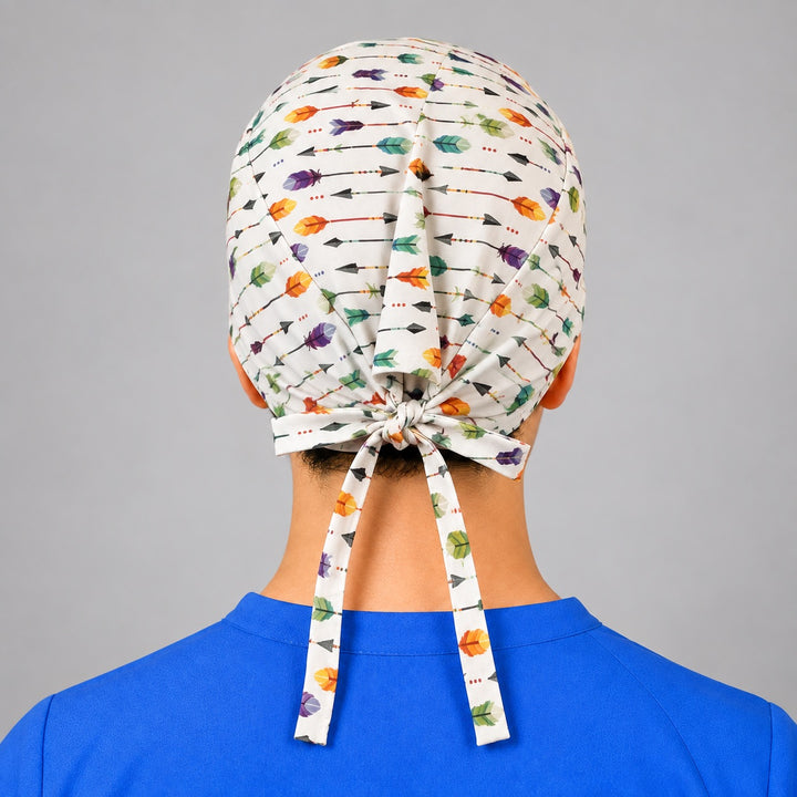 Rear knot with long ties on arrow and feather scrub hat, adjustable white cap shown from behind