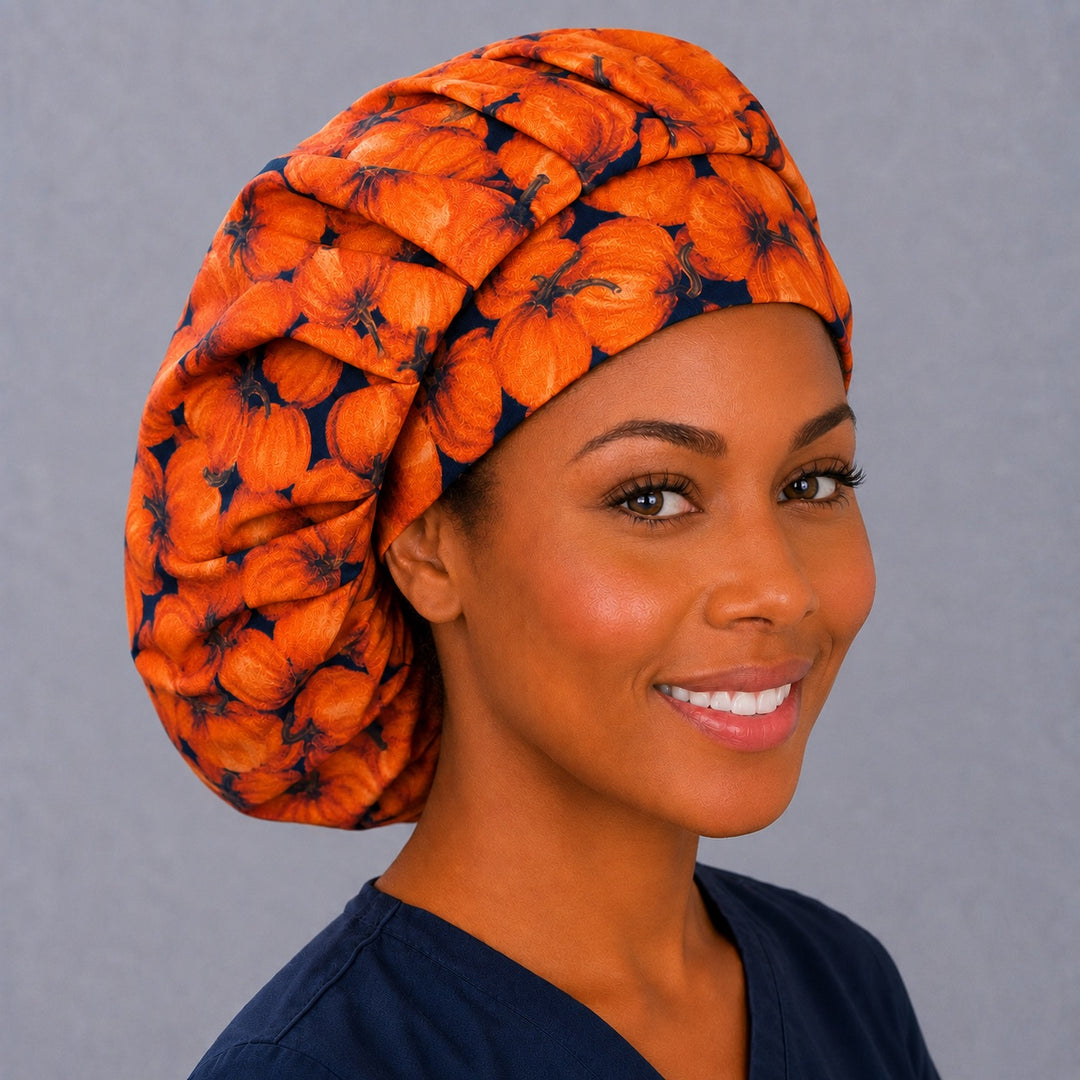Autumn pumpkin bouffant scrub cap, angled smiling view on a nurse — fall harvest print cap that secures long thick hair