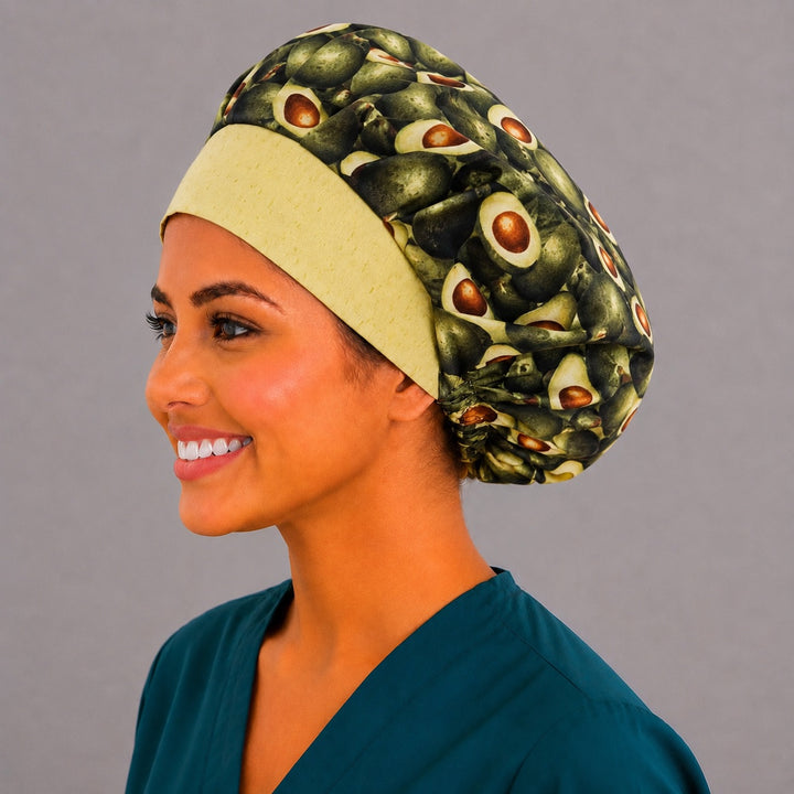 Avocado print bouffant surgical cap left side profile on smiling model showing halved avocados with yellow band, OR World foodie nurse hat