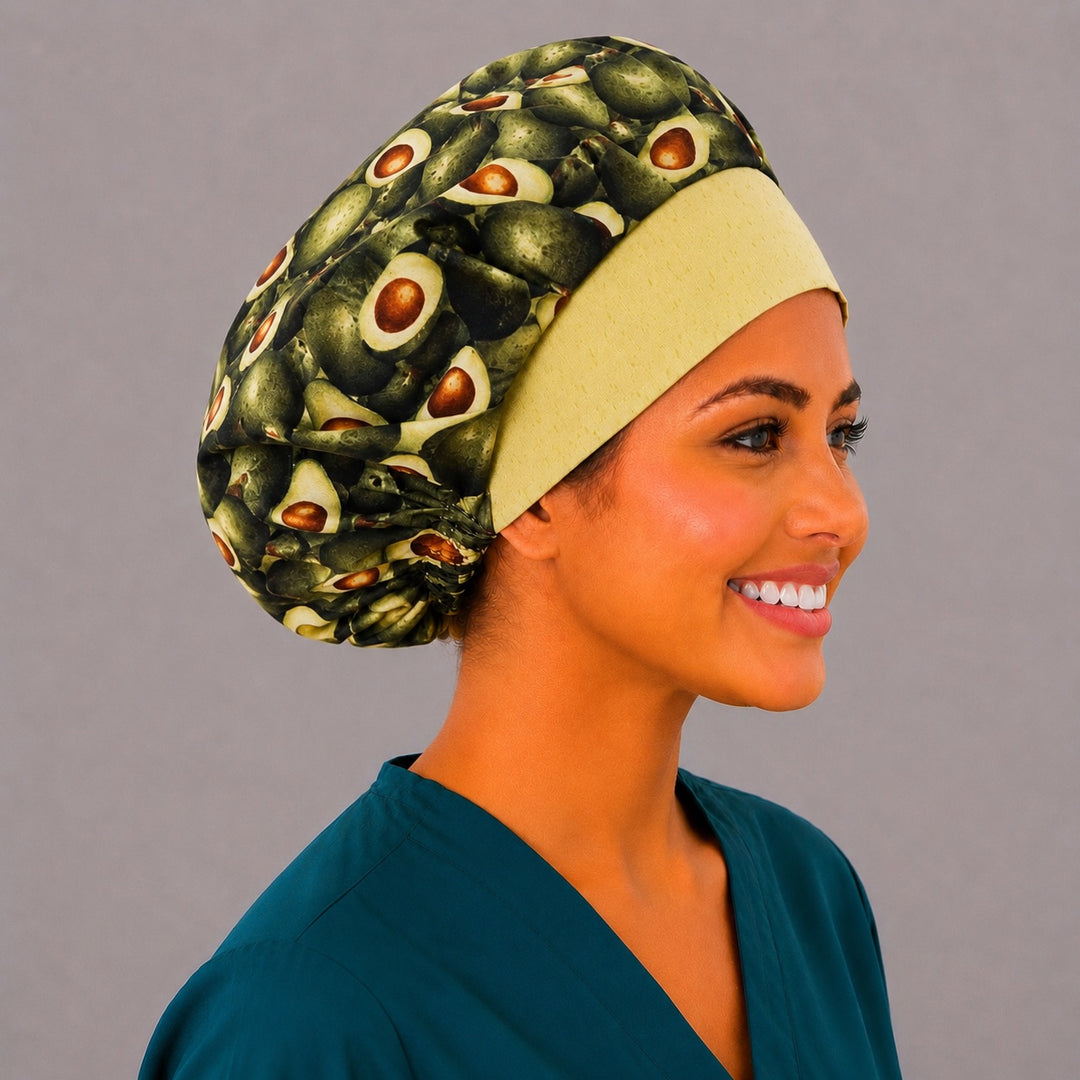 Avocado print bouffant scrub cap right side profile on smiling model showing whole and halved avocados with yellow band, women&