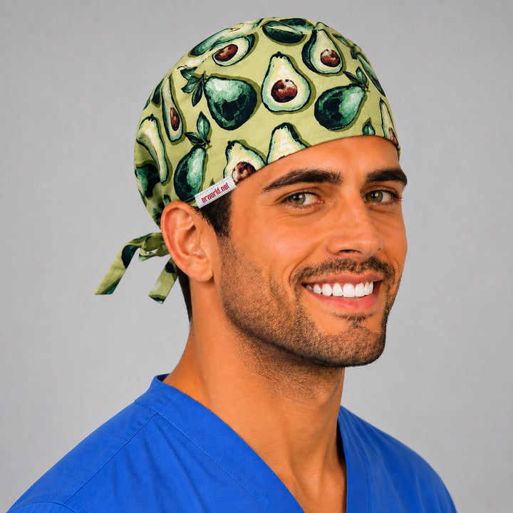 Three-quarter view of the sage green avocado scrub cap showing the avocado print and tie-back