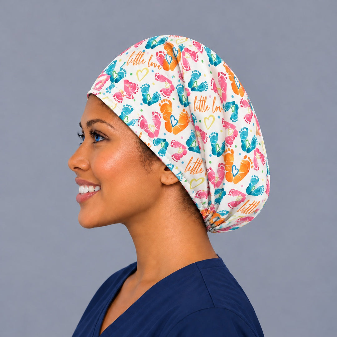 Left side profile of a baby footprint OR cap in 100% cotton, showing the adjustable elastic back and a deep crown with room for long hair or a bun