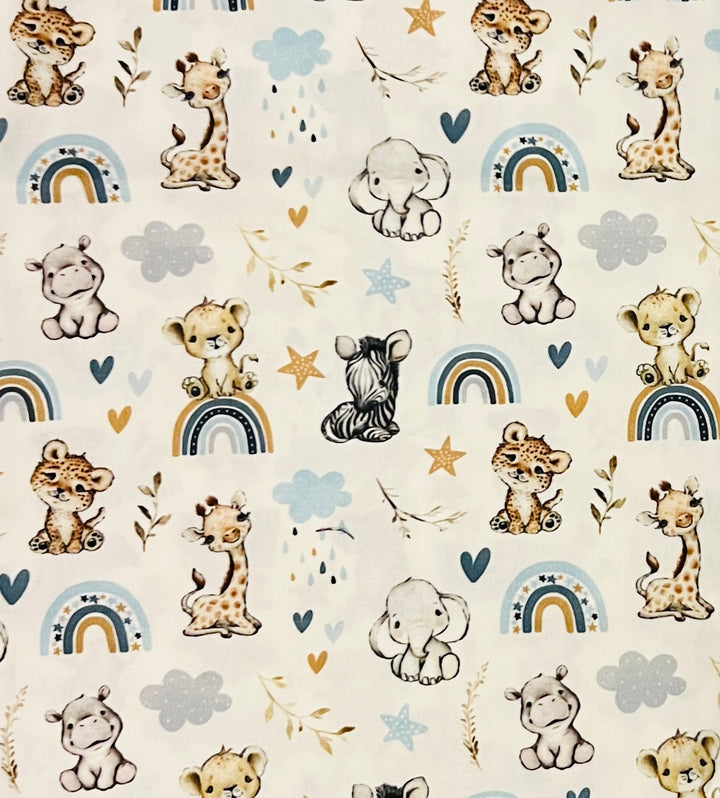 Close-up of the baby safari cotton fabric, with watercolor giraffes, elephants, hippos and cubs among blue and gold rainbows, clouds and stars on cream