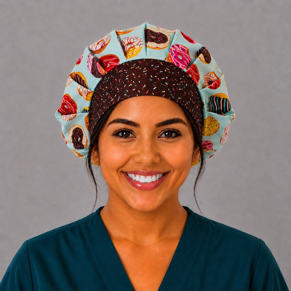 Woman wearing a bakery donut bouffant scrub cap, front view — frosted donuts on aqua with chocolate sprinkles band, adjustable women's surgical hat