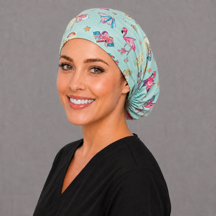 Beach flamingo Euro scrub cap, right angled smiling view — cabana and umbrella print for surgical techs and vet teams