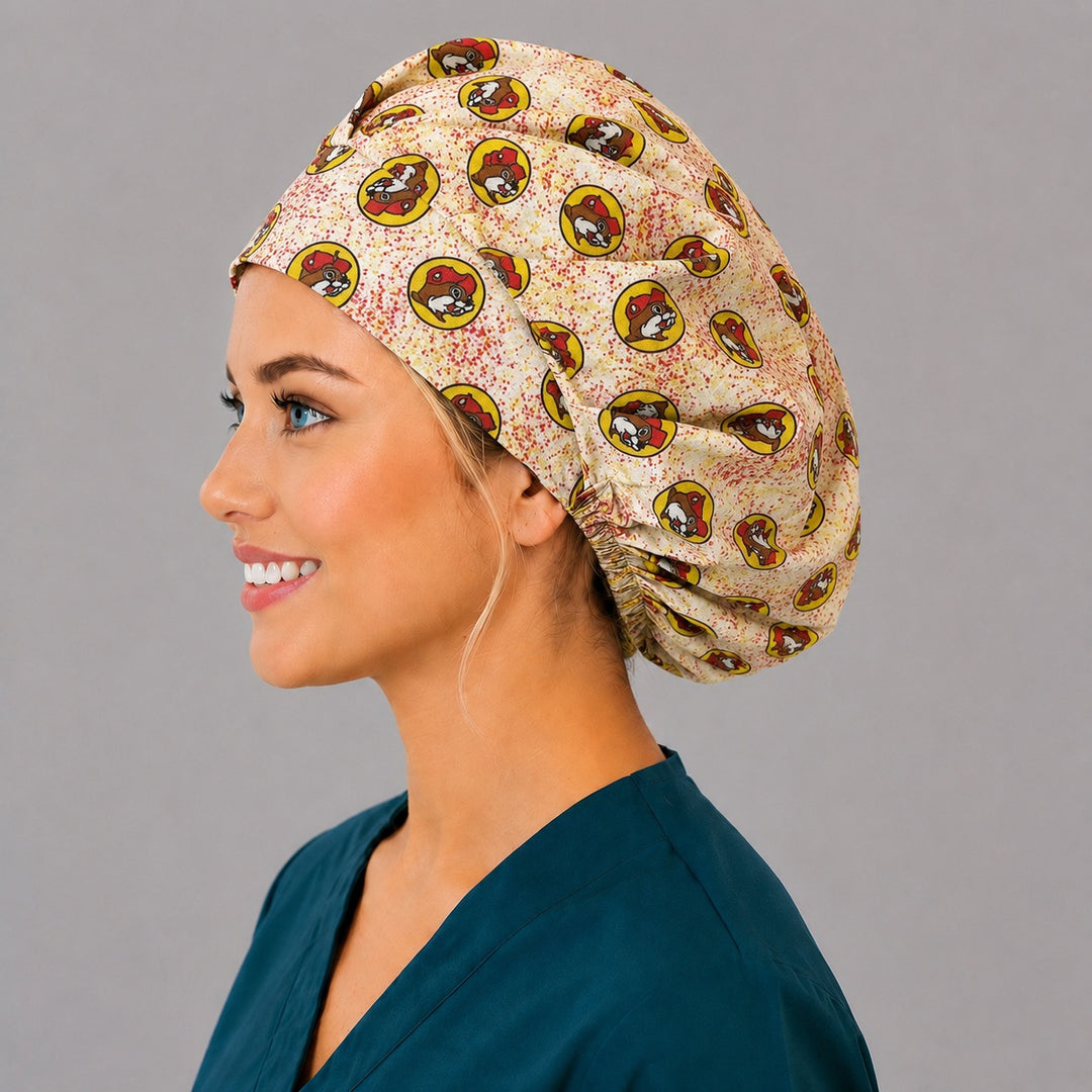 Beaver print bouffant scrub cap right side profile showing red and yellow beaver mascot badges on cream, women&