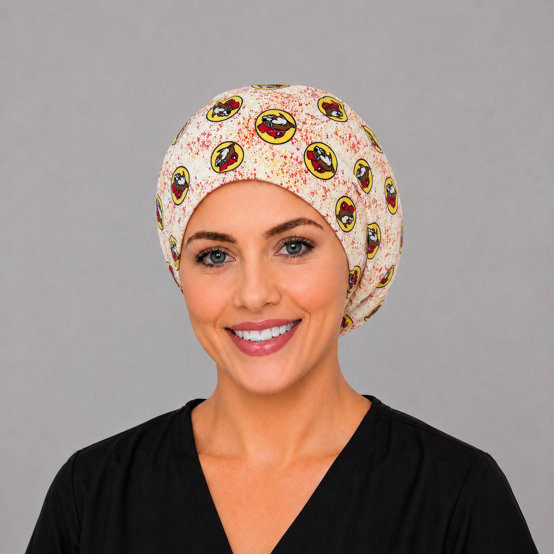 Woman wearing a beaver print Euro scrub cap, front view — cartoon beavers in red caps on cream with yellow badges, adjustable surgical hat