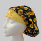 Top view of Bee Grateful sunflower & honeybee bouffant scrub cap fabric on black — handmade-in-USA OR World surgical hat for women.