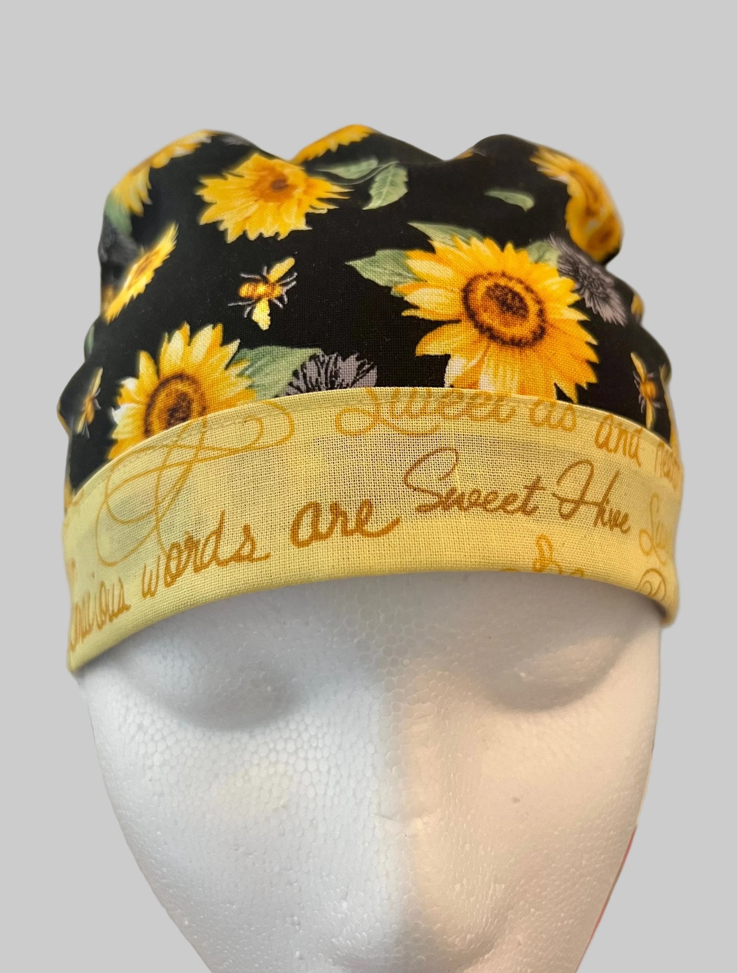 Profile view of Bee Grateful sunflower ponytail scrub cap — handmade-in-USA surgical hat with ponytail pouch, gift for nurses & sunflower lovers.
