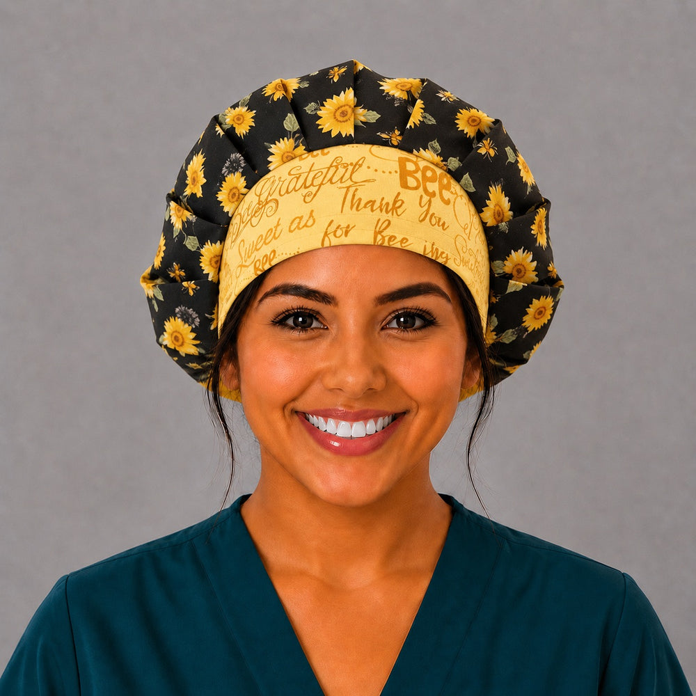 Bee Grateful sunflower bouffant scrub cap for women, front view, golden sunflowers and honeybees on black with yellow bee grateful script band, handmade surgical hat by OR World
