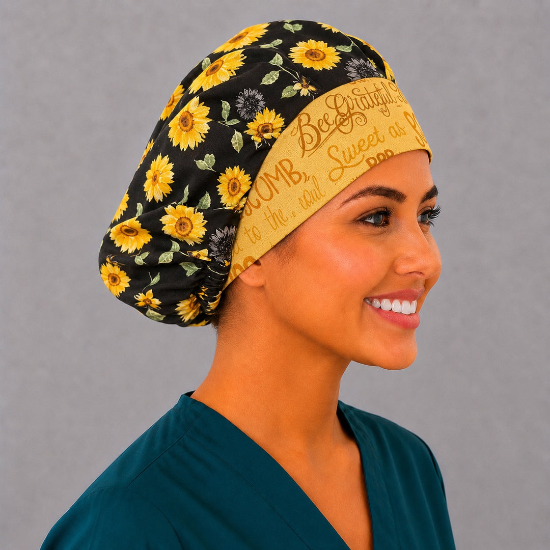 Bee Grateful sunflower bouffant scrub cap left three-quarter angle on smiling model showing golden sunflowers, honeybees and yellow script band, OR World nurse hat