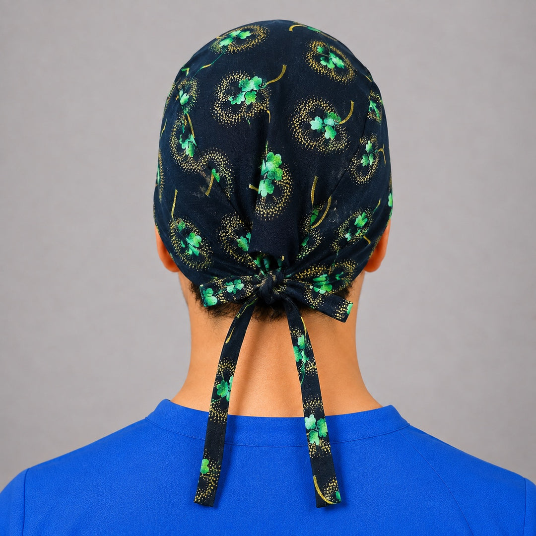 Black and gold shamrock scrub cap for short hair, handmade four-leaf clover tie-back surgical hat on OR nurse, front view