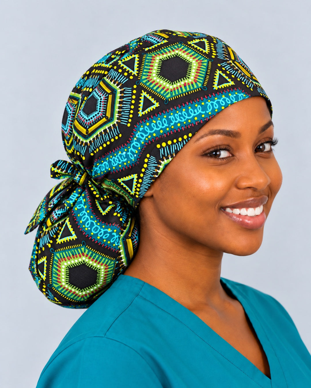 Left three-quarter view of a black and teal African surgical cap with room for locs and braids, showing the tie knot and print-matched ties above the pouch