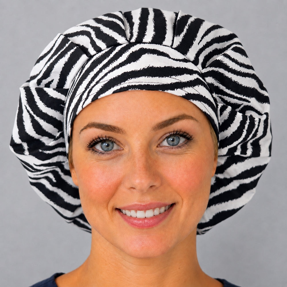 Woman wearing a black and white zebra print bouffant scrub cap, front view — classic animal stripe print, adjustable women's surgical hat