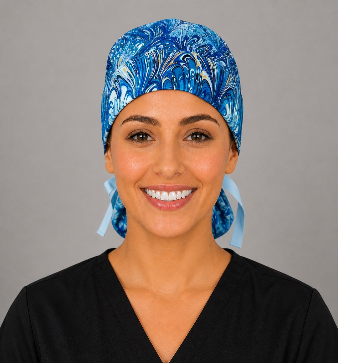 Blue marble ocean swirl ponytail scrub cap right side profile showing gathered pouch of blue, turquoise and gold marbled swirls with light blue ribbon