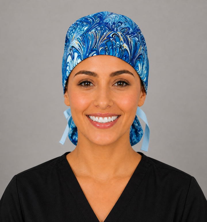 Blue marble ocean swirl ponytail scrub cap right side profile showing gathered pouch of blue, turquoise and gold marbled swirls with light blue ribbon