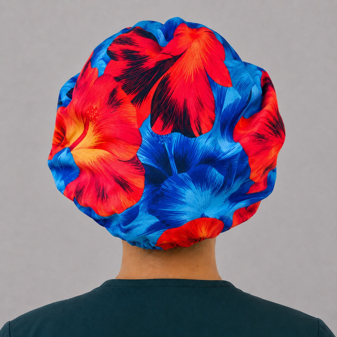 Blue and orange Hawaiian hibiscus bouffant scrub cap left side profile showing blue red and orange hibiscus flowers, OR World tropical nurse hat