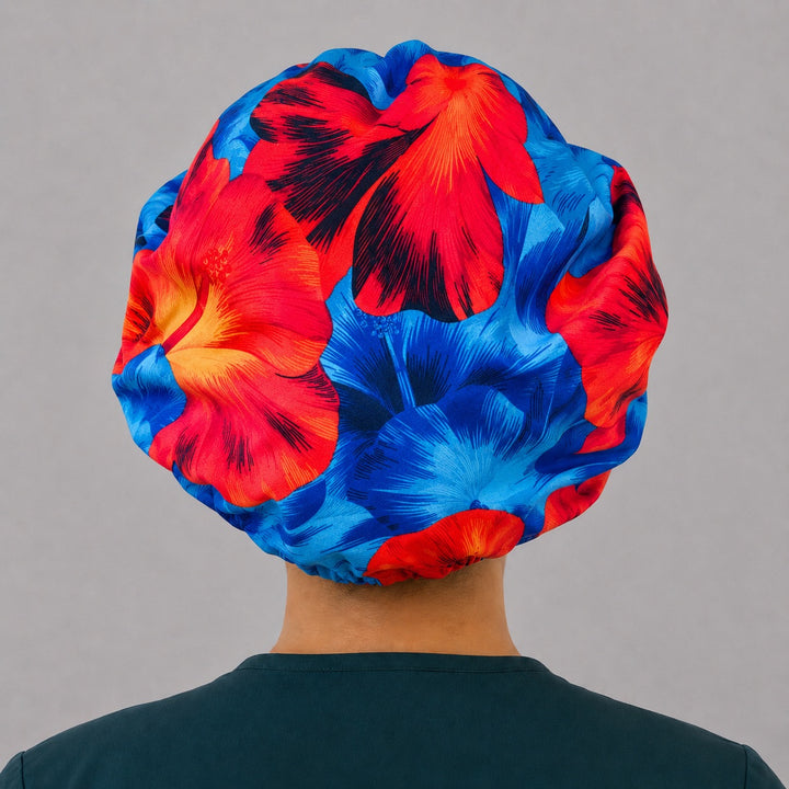 Blue and orange Hawaiian hibiscus bouffant scrub cap left side profile showing blue red and orange hibiscus flowers, OR World tropical nurse hat